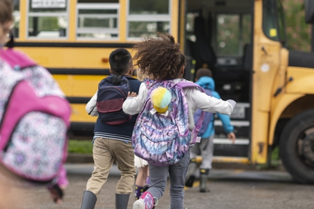 children running to a school bus