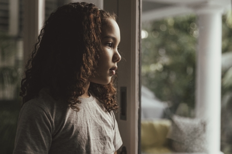 sad child looking out the window