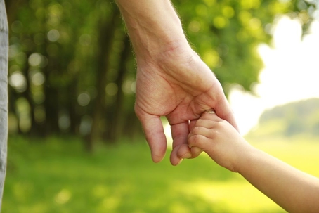 Adult holding a child's hand